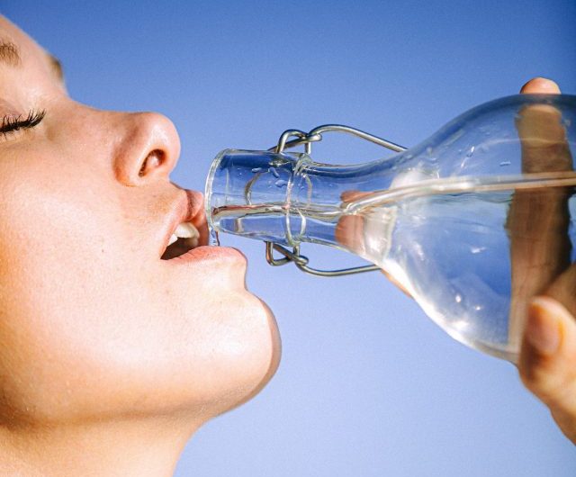 Mulher bebendo água na garrafa